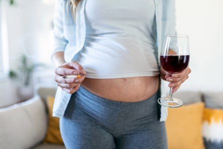 Mujer embarazada tomando vino